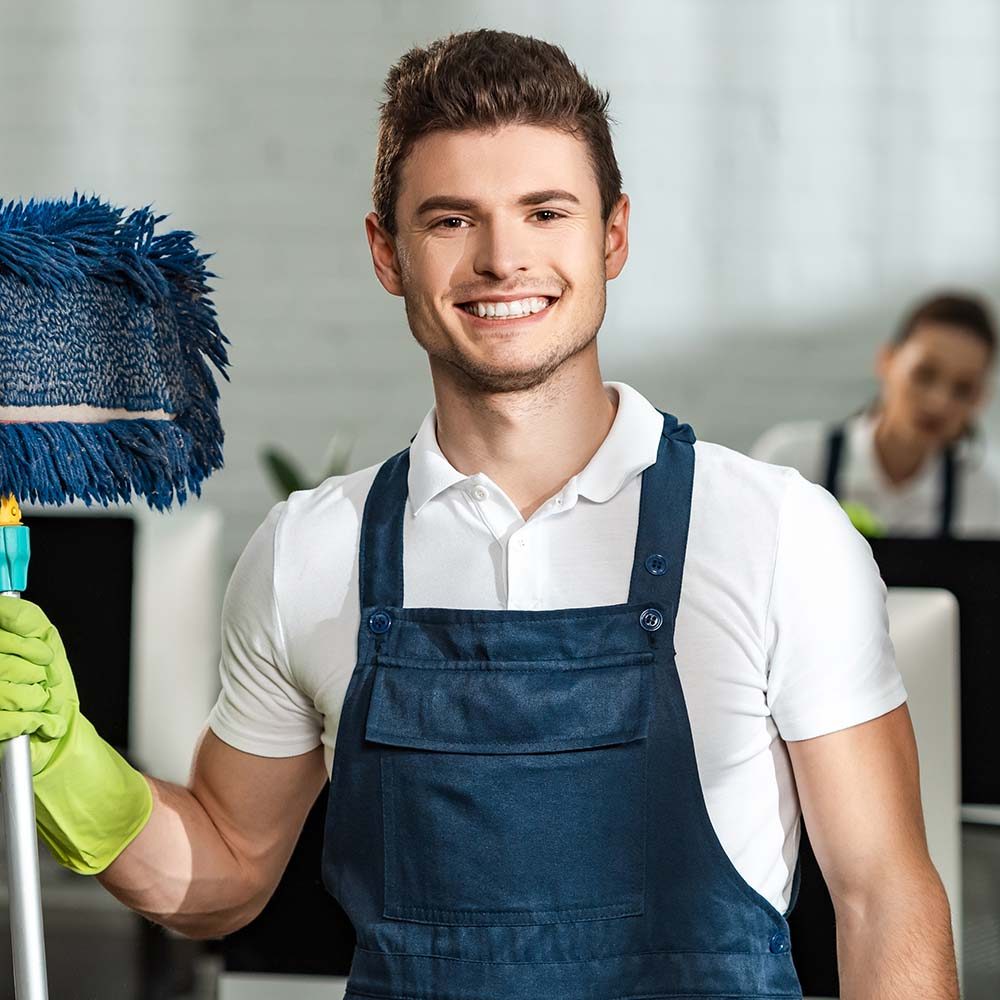 cheerful-cleaner-holding-mop-while-looking-at-came3-NANDH2L-1.jpg
